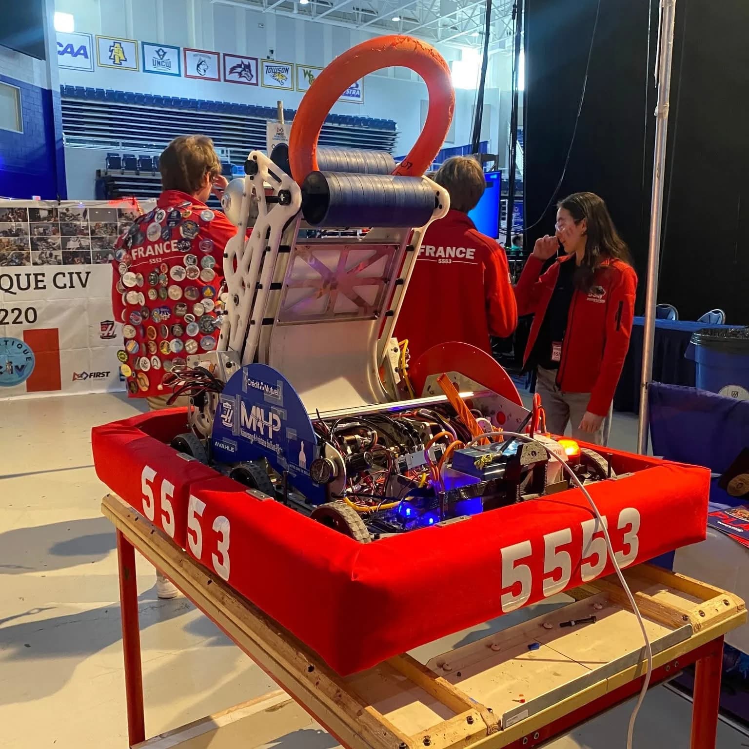 Robot Robo’Lyon numéro 5553 en compétition, avec son mécanisme principal ouvert et ses bumpers rouges.